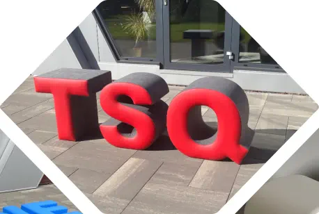 rote Buchstaben TSQ als Sitzhocker stehen aufrecht vor einem Büro